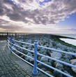 Railing along stone walkway near beach