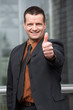 Foto: motivierter geschäftsmann zeigt daumen hoch motivierter geschäftsmann zeigt daumen hoch