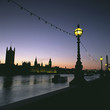 Streetlights along urban river at sunset