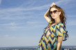 beautiful girl in sunglasses on background blue sky