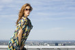 beautiful girl in sunglasses on background blue sky