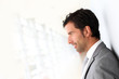 Businessman standing on white wall- profile view