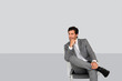 Businessman sitting on chair on grey background