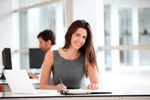Foto: Attractive businesswoman working on laptop computer Attractive businesswoman working on laptop computer