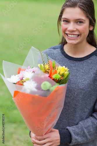 Photo: Young girl holding a bunch of flowers Young girl holding a bunch of flowers