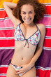 Overhead view of an attractive young woman smiling while lying o