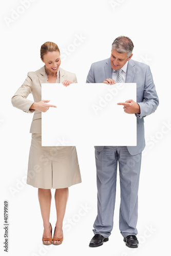 Photo: Smiling business people holding a poster Smiling business people holding a poster