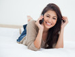 Foto: Woman smiling and looking in front of her as she makes a phoneca Woman smiling and looking in front of her as she makes a phoneca
