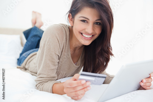 Foto: Woman looking straight ahead, with her credit card and tablet in Woman looking straight ahead, with her credit card and tablet in