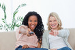 A woman pointing a television remote control at the camera with