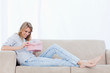 A happy woman looks at a present inside a pink box