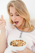 Close up, Woman about to eat a spoon of cereal, with a bowl in h
