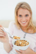 Focus shot, woman offering a spoon of cereal, focused on the spo