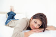 Woman lying on the bed, her hands under her head with her feet c