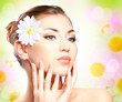 Foto: Spa beautiful girl with camomile touching her face Spa beautiful girl with camomile touching her face