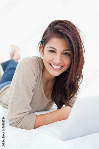 Photo: Woman smiling infront of her tablet, as she looks in front of he Woman smiling infront of her tablet, as she looks in front of he