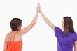 Two friends joining their hands in the air
