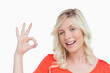 Young blonde woman showing the OK sign and a blink of an eye