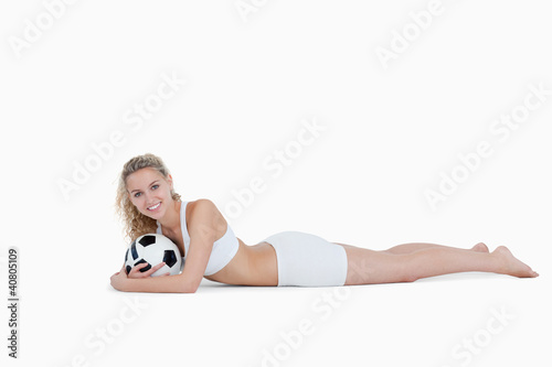 Photo: Smiling teenager holding a football close to her Smiling teenager holding a football close to her