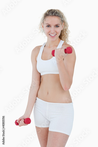 Photo: Smiling teenager looking at the camera while lifting weights Smiling teenager looking at the camera while lifting weights
