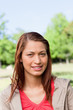 canvas print picture - Young woman smiling as she looks into the distance while in a br