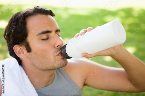 Photo: Man drinking from a sports bottle with his eyes closed Man drinking from a sports bottle with his eyes closed