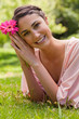 Woman restling her head against her arms while holding a flower