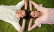 Two friends lying head to head with both hands behind their neck