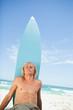Young relaxed man sitting on the beach while sunbathing