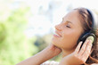 canvas print picture - Side view of a woman enjoying music in the park