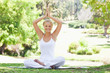 Smiling woman sitting in a yoga position outdoors