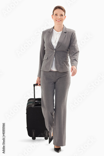 Photo: Businesswoman walking forward with a suitcase Businesswoman walking forward with a suitcase