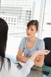 canvas print picture - A brunette worker listens to her co-worker