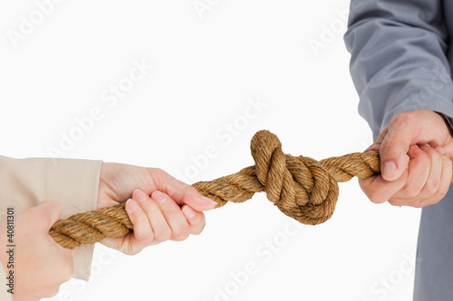 Photo: Business people tightening a knot Business people tightening a knot