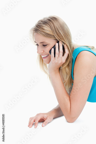 Photo: A smiling young woman is talking on her mobile phone A smiling young woman is talking on her mobile phone