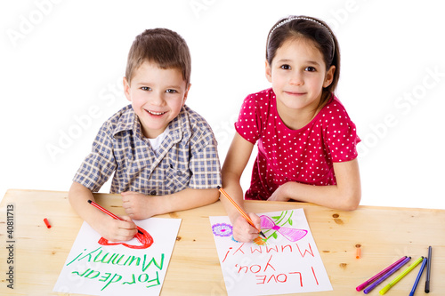 Photo: Two smiling kids draw for mum Two smiling kids draw for mum