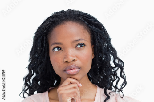 Photo: Head shot of a young woman who is thinking Head shot of a young woman who is thinking