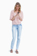 An angry woman standing looking at her mobile phone