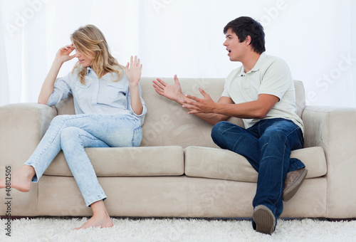 Photo: A man is having an argument with his girlfriend while sitting on A man is having an argument with his girlfriend while sitting on