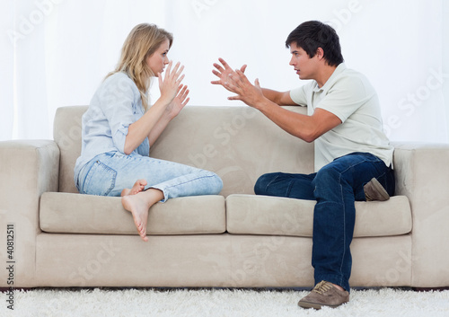 Foto: A couple sitting on a couch are having an argument A couple sitting on a couch are having an argument