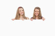 Close-up of two young women holding a blank sign