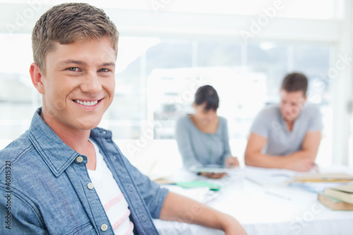 Foto: Focus shot on a male student with his friends in the background Focus shot on a male student with his friends in the background