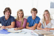 canvas print picture - A smiling group of student sitting and looking at the camera