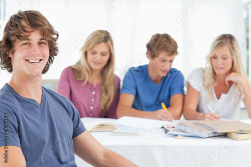 Foto: Close up of a smiling man sitting in front of his friends Close up of a smiling man sitting in front of his friends