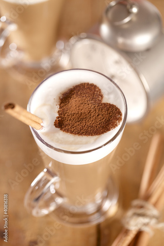 Photo: coffee latte with cinnamon sticks and cacao heart , shallow dof coffee latte with cinnamon sticks and cacao heart , shallow dof