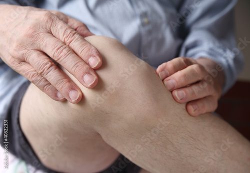 Photo: man experiencing sore knee man experiencing sore knee