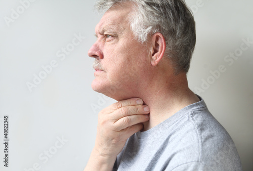 Photo: a senior is suffering from a sore throat a senior is suffering from a sore throat