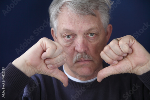 Photo: an older man with both thumbs down an older man with both thumbs down