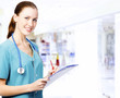 Photo: Smiling female medical doctor with clipboard in a corridor of a Smiling female medical doctor with clipboard in a corridor of a