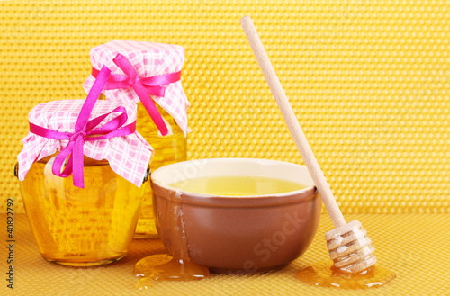 Photo: Jars of honey, bowl and wooden drizzler with honey Jars of honey, bowl and wooden drizzler with honey